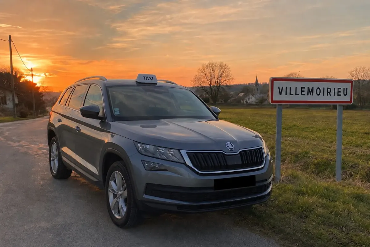 Taxi Škoda Kodiaq gris Tara Taxi devant le panneau de Villemoirieu